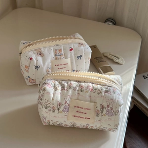 Detail of quilted cosmetic bag with cute dog and cherry prints on soft fabric