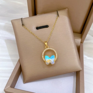 Close-up of sparkling butterfly pendant with blue crystal inlay on champagne silk