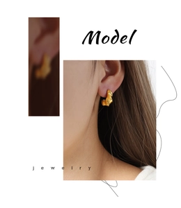 Detailed view of model wearing twisted C-shape hollow earrings in 18k gold plating