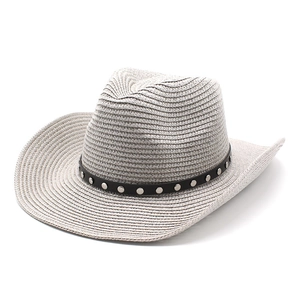Detail of woven straw cowboy hat with silver studs on a black decorative band
