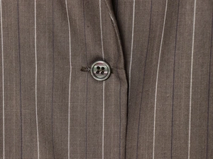 Macro de la veste à rayures avec bouton nacré haut de gamme et couture détaillée