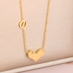 Détail du pendentif cœur 3D sur un collier en acier titane plaqué or poli et brillant