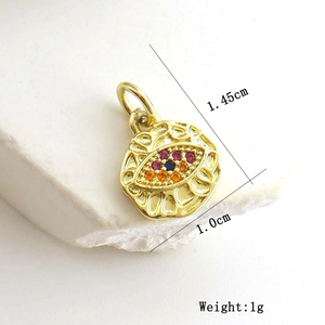 Detail view of a gold evil eye pendant with tri-color zircon and size measurements
