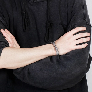 Détail du bracelet punk vintage en acier avec deux têtes de loup sur un poignet masculin
