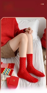 Detail of red combed cotton mid-tube socks with cable knit texture for holiday wear