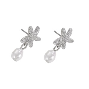Detalle de pendientes de estrella de mar con micro circonitas y perla barroca