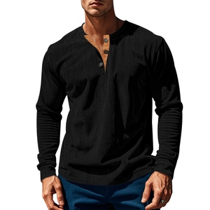Detailansicht des schwarzen Rippstoffes und der kontrastierenden braunen Knopfleiste am Shirt