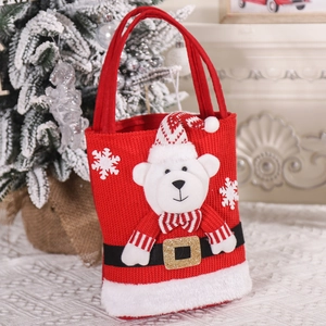 Close-up of red knitted Christmas gift bag with 3D polar bear and snowflake embroidery