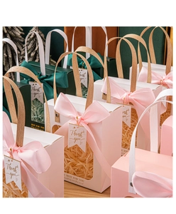 Close-up of premium gift bags with transparent windows, ribbon bows, and woven handles