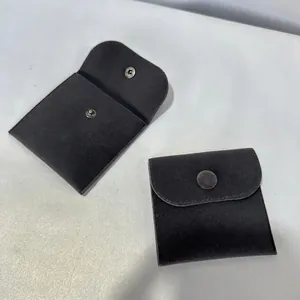 Detailed close-up of dark grey velvet jewelry pouch showing snap closure and soft flap