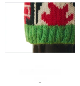 Macro view of Christmas wine bottle cover with red jacquard pattern and rib knit cuff