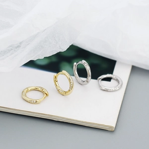 Macro shot of gold and silver S925 sterling silver hoop earrings with pavé crystals