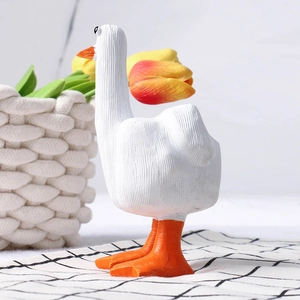 Detail of creative resin Duck You figurine on a checkered cloth with a woven basket background