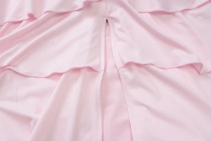 Macro shot of pink layered ruffled fabric and stitching detail on a strapless maxi dress