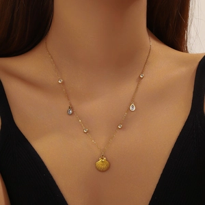 Gold plated stainless steel necklace featuring a shell pendant and teardrop crystal accents