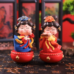 Detail of two Q-style Tang Dynasty roly-poly figurines on red drum bases for desk decor