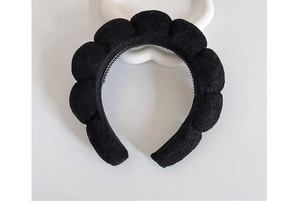 Top view of black velvet cloud headband with soft puff design on white background