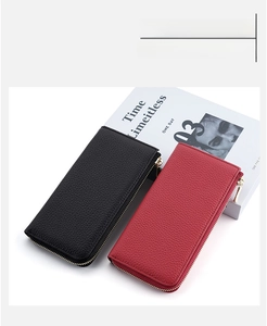 Close-up of black and red leather wallets with lychee pattern and gold zipper detail