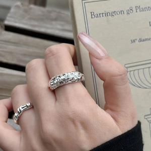 Detailed view of bohemian silver ripple wide ring and twisted rope band on hand