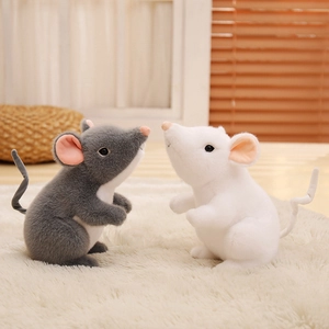Cute plush mouse dolls in grey and white colors sitting on a soft cozy carpet