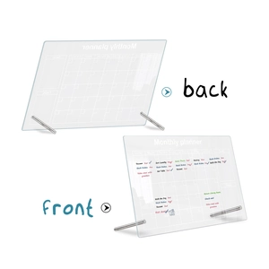 Macro view of clear acrylic monthly planner board showing front and back with silver stands