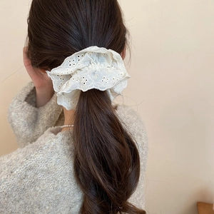 Detailed view of a white double-layer floral lace scrunchie styled on a ponytail