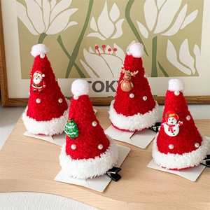 Detailed view of plush Christmas hat hair clips with mini 3D figurines on a wooden tray