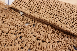 Close-up of hand-woven crochet bag featuring brown hollow pattern and metal zipper closure
