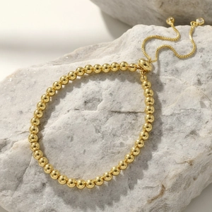 Detail of 18K gold plated bead bracelet showing adjustable slider clasp and zircon stones
