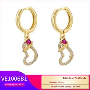 Close-up of gold Christmas sock earrings with red stones and zircon details