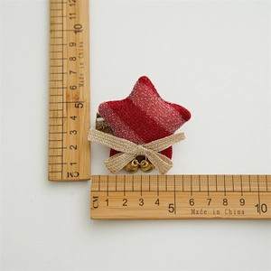 Red glitter star hair clip with beige bow and gold bells measuring 5cm in size