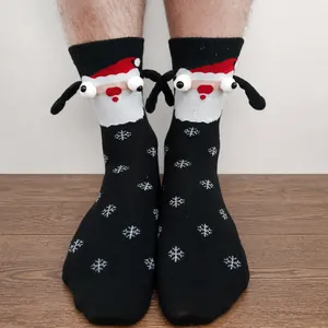 Detail of Christmas magnets socks with 3D Santa Claus and white snowflake patterns