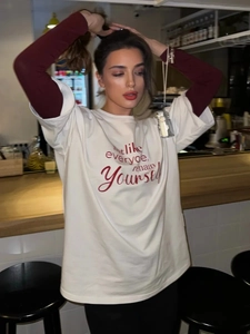 Λευκό oversized βαμβακερό T-shirt με κόκκινα γράμματα και στυλ layering στα μανίκια