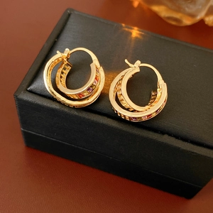 Detail of vintage gold double hoop earrings featuring colorful square inlaid gemstones