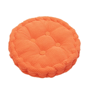 Detail of orange corduroy round chair cushion with tufted buttons and textured fabric