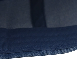 Macro view of navy denim baseball cap showing reinforced stitching and twill fabric texture