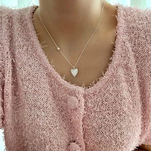 Detail of 925 sterling silver irregular heart pendant necklace with pearl on model