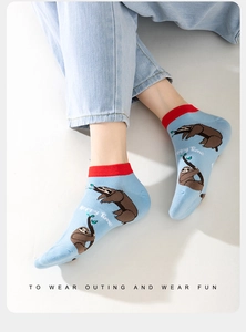 Detail of light blue cotton low cut sock with red rib cuff and cute sloth pattern