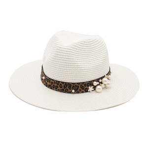 Close-up of leopard ribbon with elegant pearls and floral detail on straw Panama hat