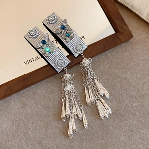 Detailed shot of silver tassel earrings with butterfly motif and sparkling crystals