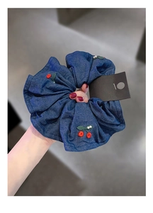 Detail of navy denim hair scrunchie with red cherry embroidery and white pearls