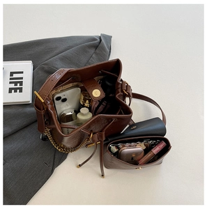 Détail d'un sac seau en cuir marron montrant sa grande capacité pour mobile et cosmétiques