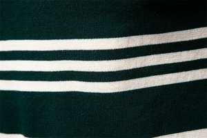 Detailed macro view of the dark green and white striped knit fabric and soft texture