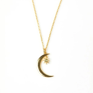 Close-up of golden crescent moon and star pendant with green gemstone on S925 silver chain