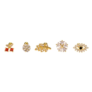 Five gold piercing studs set with cubic zirconia including cherry and evil eye designs
