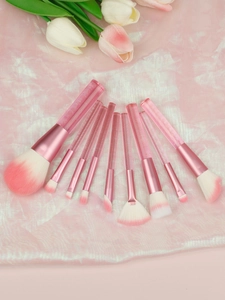 Close-up of 10-piece makeup brush set with clear pink handles and rose gold ferrules