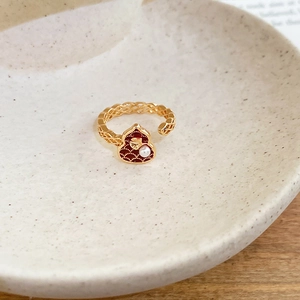 Detailed close-up of a vintage 18k gold plated open ring with hulu gourd and red enamel