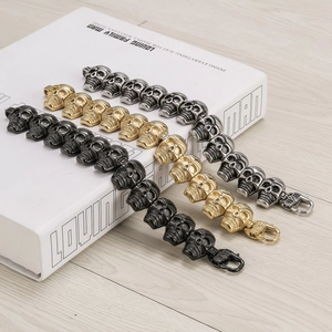 Three punk skull bracelets in black, gold, and silver finishes with lobster clasp detail