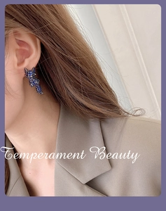 Detail of blue rhinestone fox earrings on model showing precise animal design
