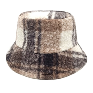 Detailed texture of brown plaid lamb wool bucket hat with soft curly fleece fabric